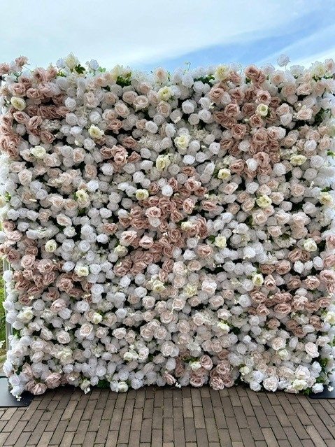 Flowerwall met roze rozen als decoratie naast de photobooth